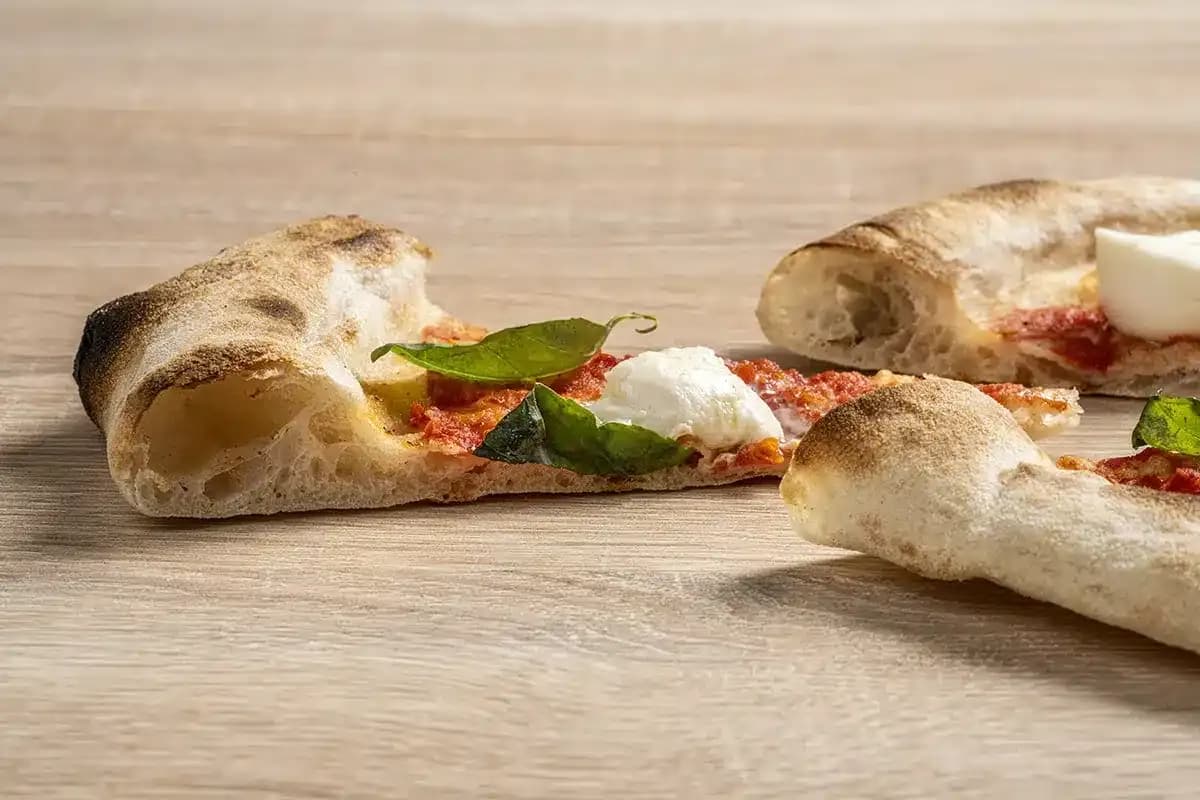 Genomskuren kant av en gräddad pizza, luftig inuti