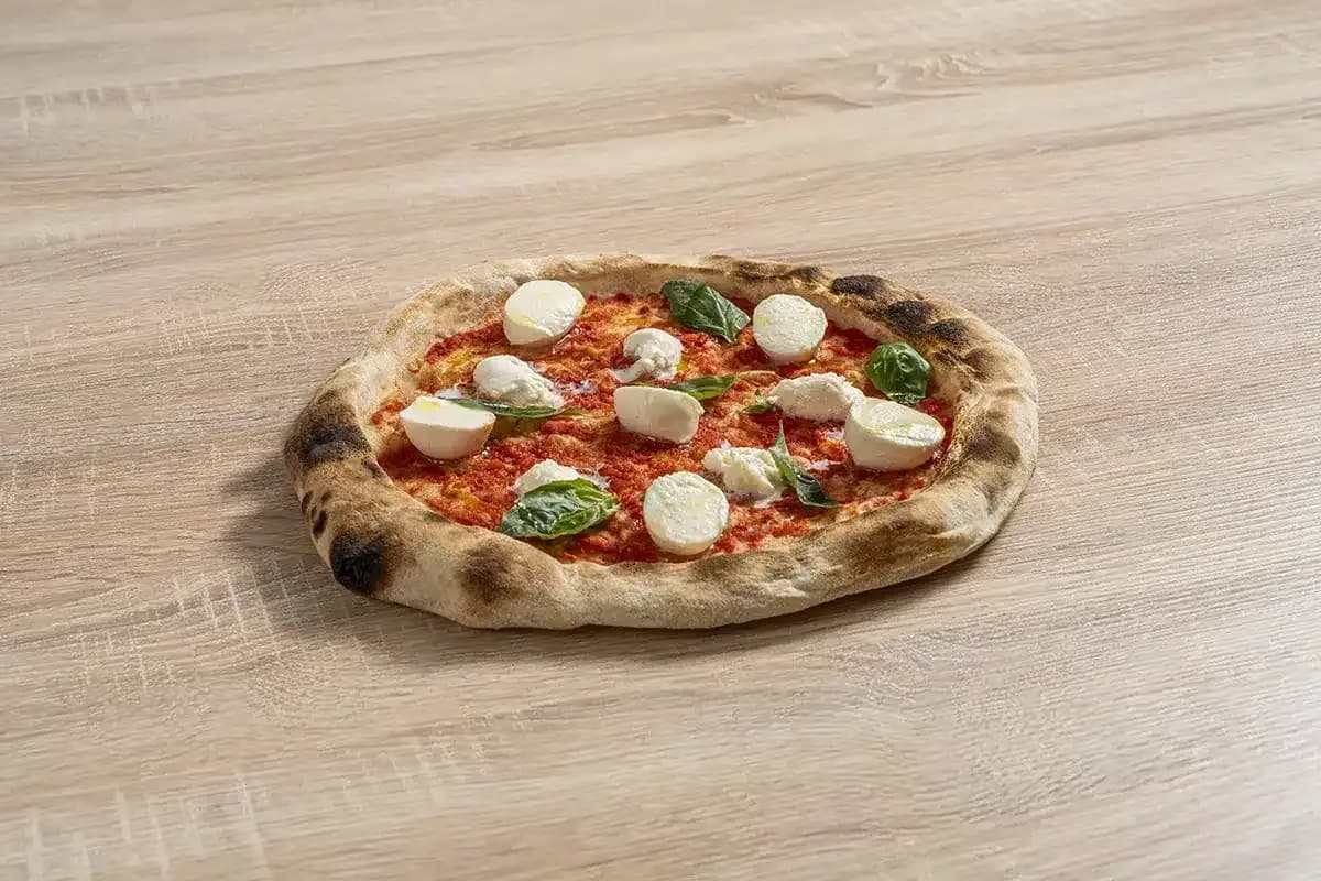 Färdig pizza med tomat, mozzarella och basilika
